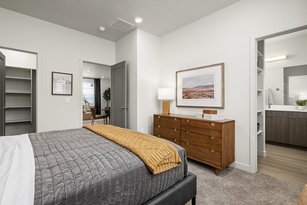 a bedroom with a bed and a dresser and a bathroom