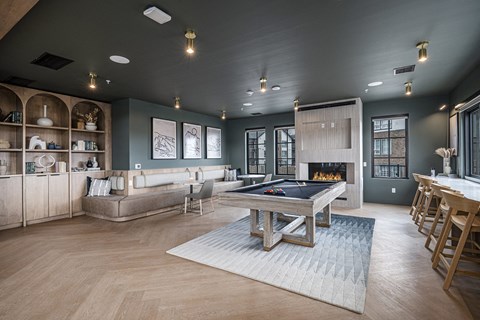 a large living room with a pool table and a kitchen