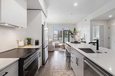 A modern kitchen with a black stove top oven and white cabinets.