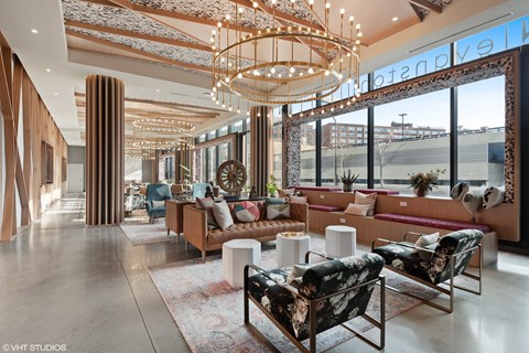 A modern living room with a large window and a chandelier.
