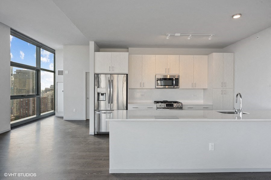 a large white kitchen with white cabinets and a large window