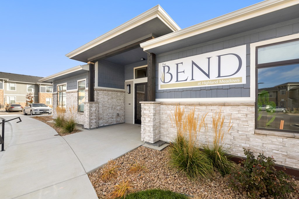 a sidewalk in front of a building with a mend logo on it