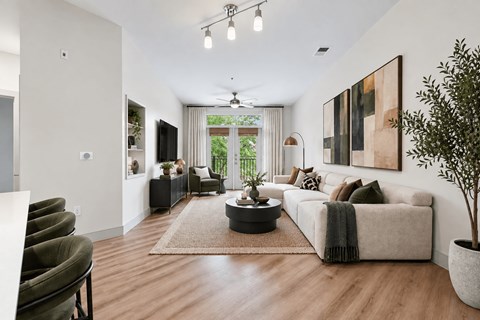 A modern living room with a large couch, a coffee table, and a potted plant.