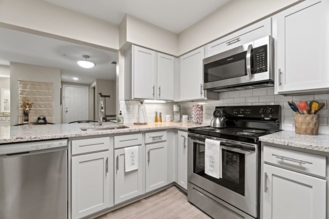 A kitchen with white cabinets and stainless steel appliances.
