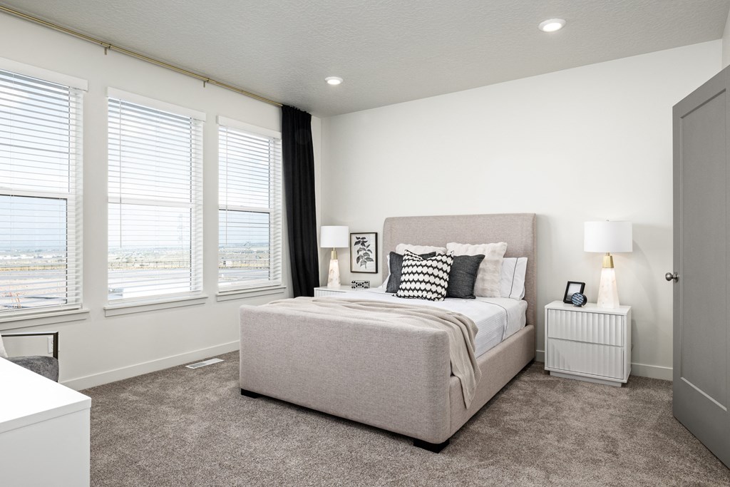 a bedroom with a bed and three windows