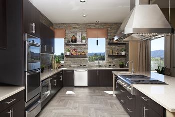 a kitchen with stainless steel appliances and a stone wall