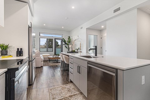 A modern kitchen with stainless steel appliances and a dining area with a table and chairs.