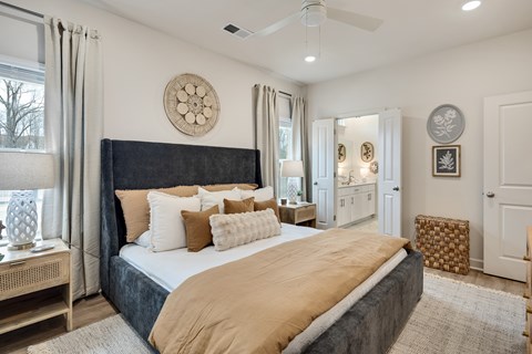 A bedroom with a large bed and a ceiling fan