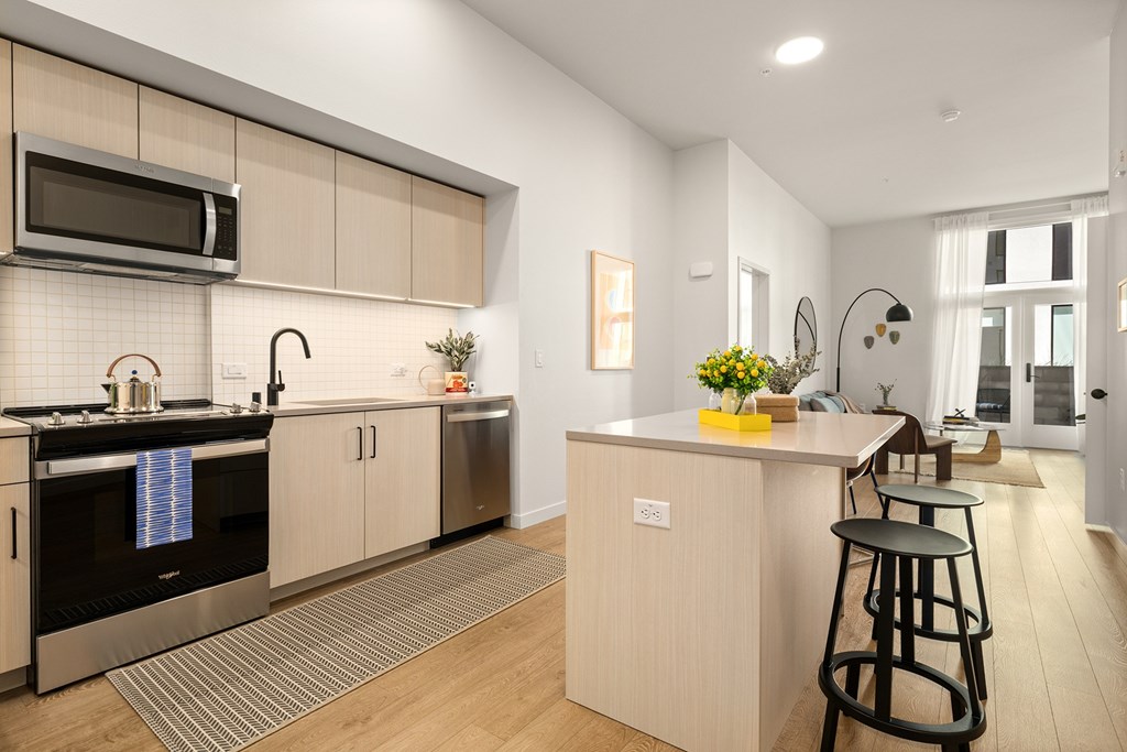 A modern kitchen with a bar stool in front of it.