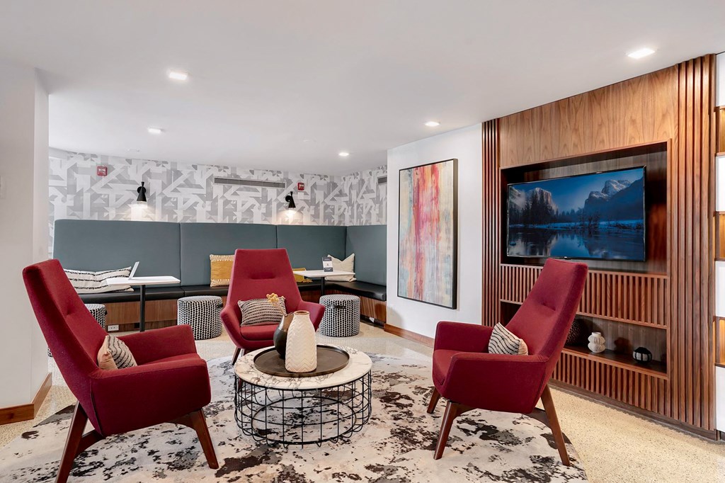 a living room with red chairs and a television