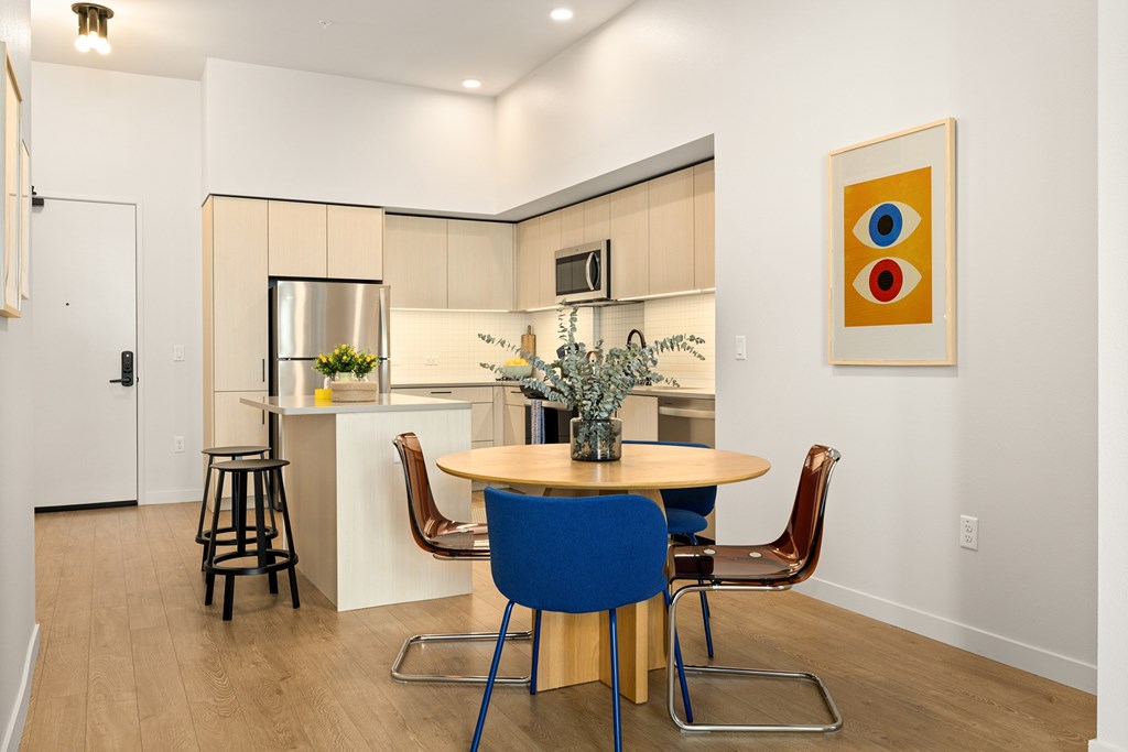 A kitchen with a table and chairs.