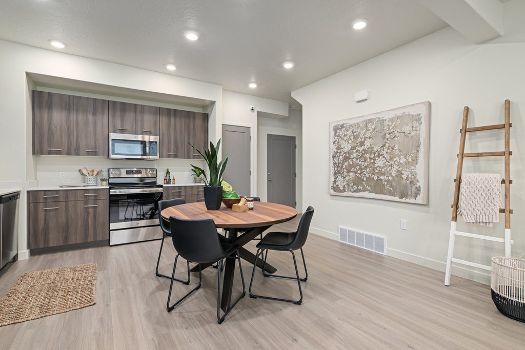 A modern kitchen with a dining table and chairs.