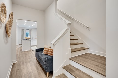 A living room with a couch and a staircase.