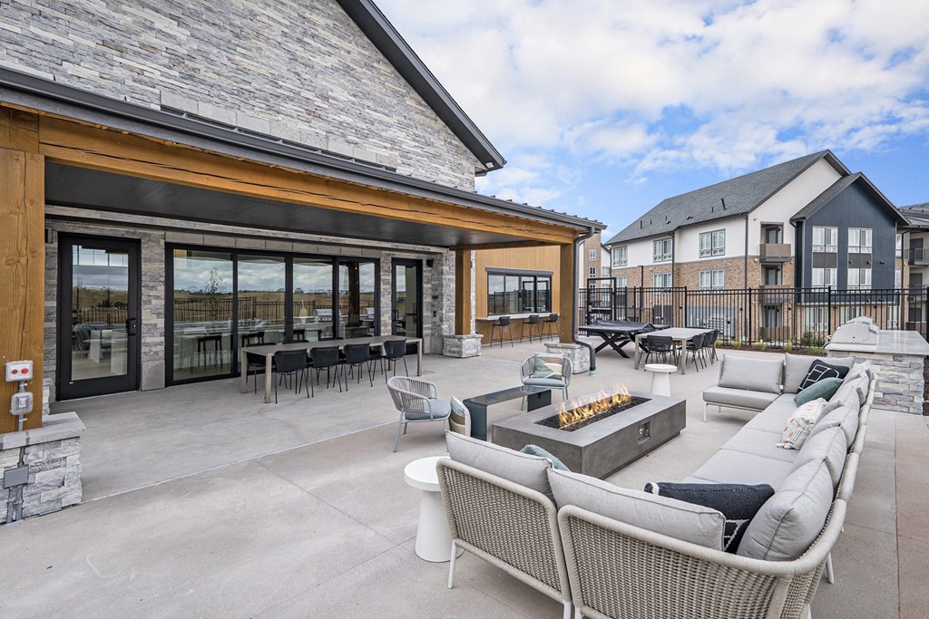 the outdoor patio of a home with furniture and a fire pit