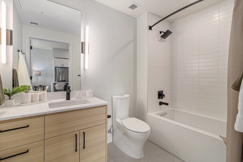 A white bathroom with a toilet, sink, and bathtub.