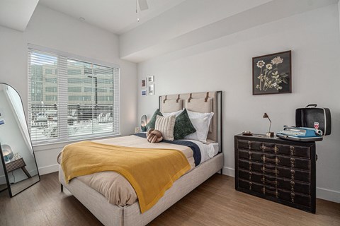 a bedroom with a bed and a large window