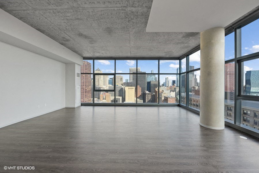 an empty living room with a view of a city skyline