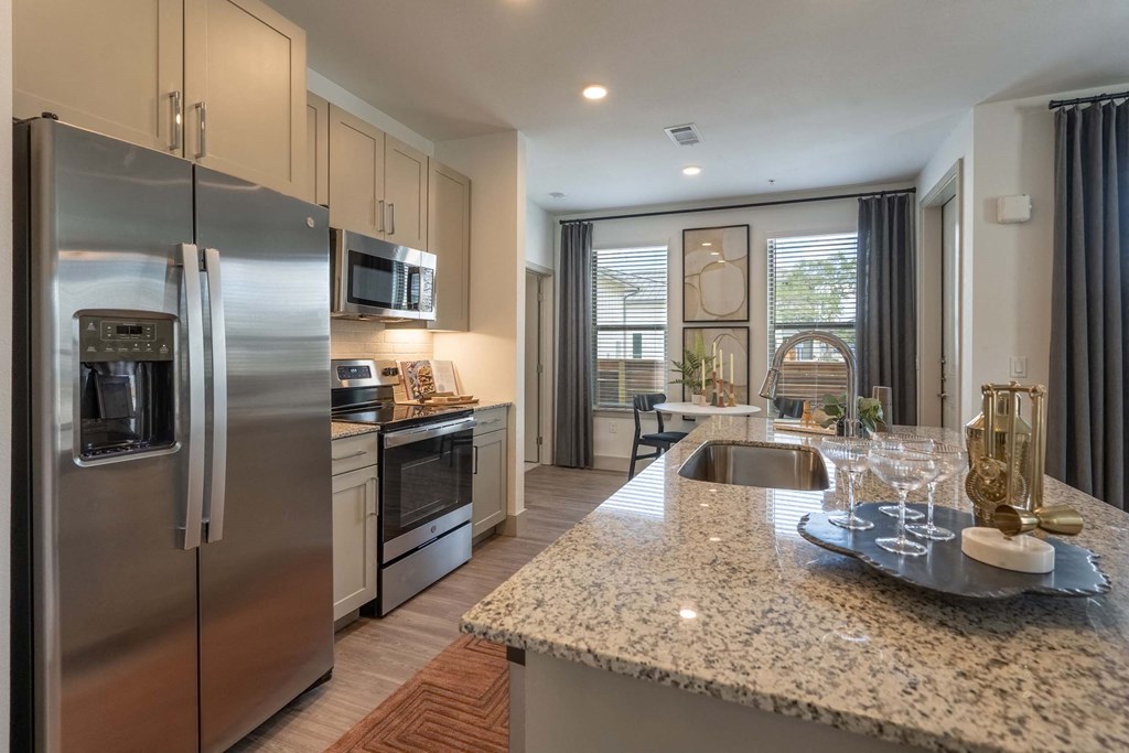 a kitchen with stainless steel appliances and granite counter tops