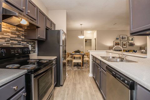 A kitchen with a black stove top oven and a black refrigerator.