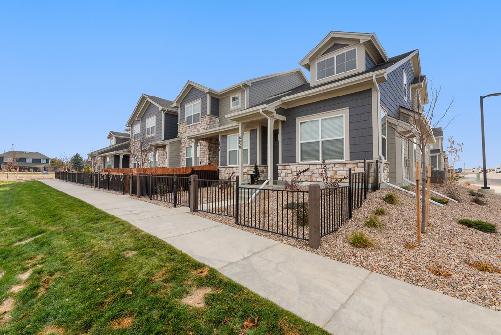 a row of houses on the side of a sidewalk