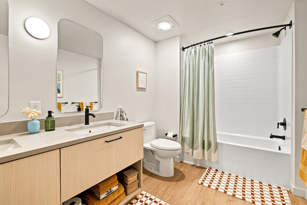 A bathroom with a toilet, sink, and shower.