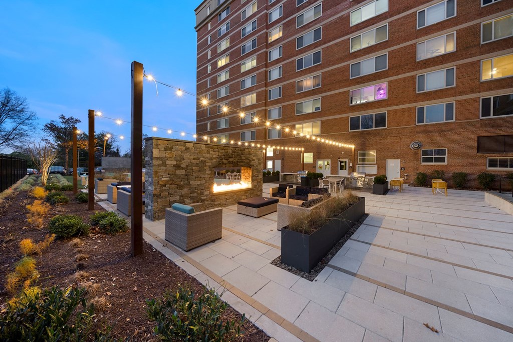 a courtyard with a fireplace and a large brick building