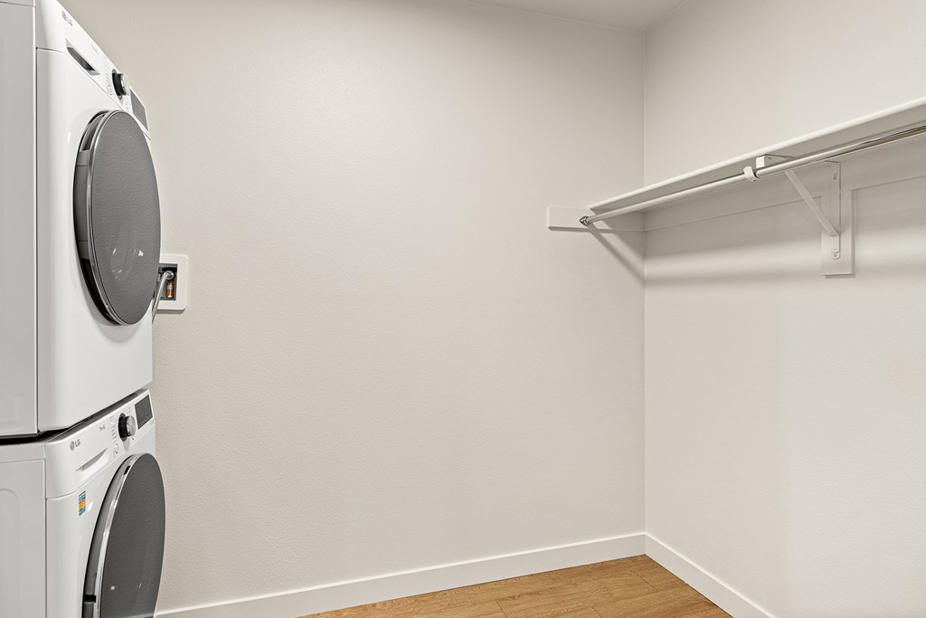 A white dryer is on the left of a white wall.