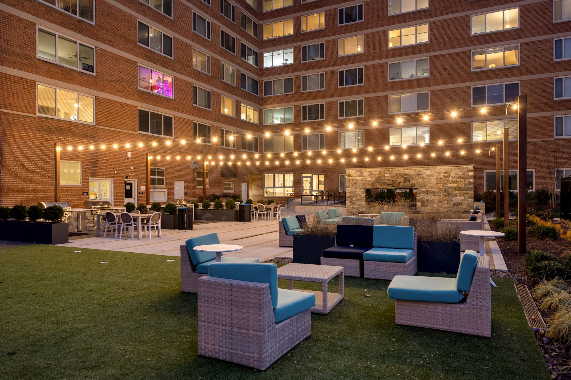 an outdoor lounge area of an apartment building with chairs and tables