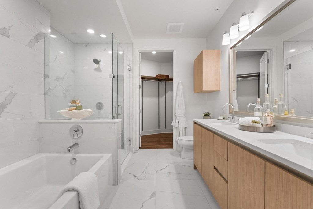 a bathroom with a white bathtub and a shower with a glass door at Stanza Little Italy, California