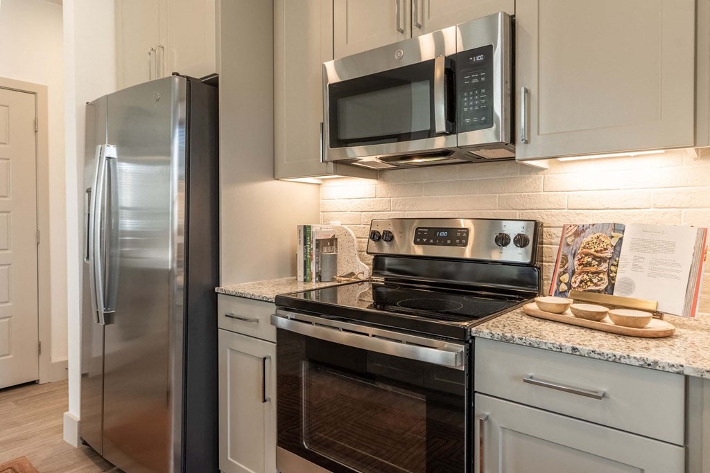 a kitchen with stainless steel appliances and white cabinets
