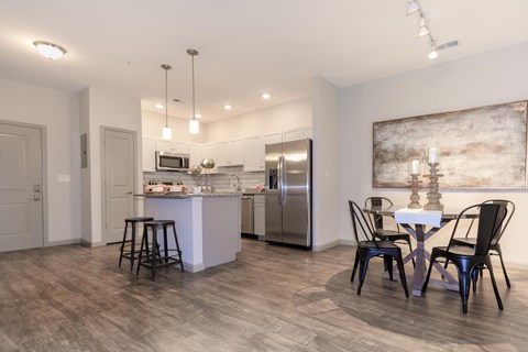 A kitchen with a dining table and chairs.