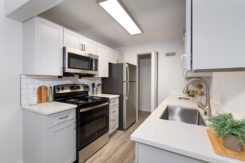 a kitchen with white cabinets and stainless steel appliances