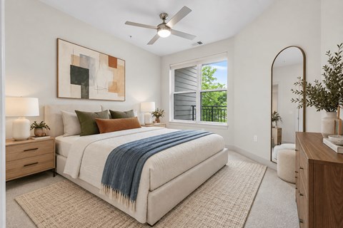 A bedroom with a large bed and a ceiling fan.