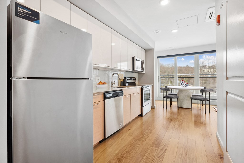 a kitchen with stainless steel appliances and a table with chairs