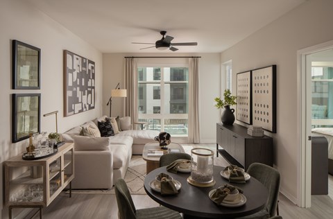A modern living room with a dining table set for two.