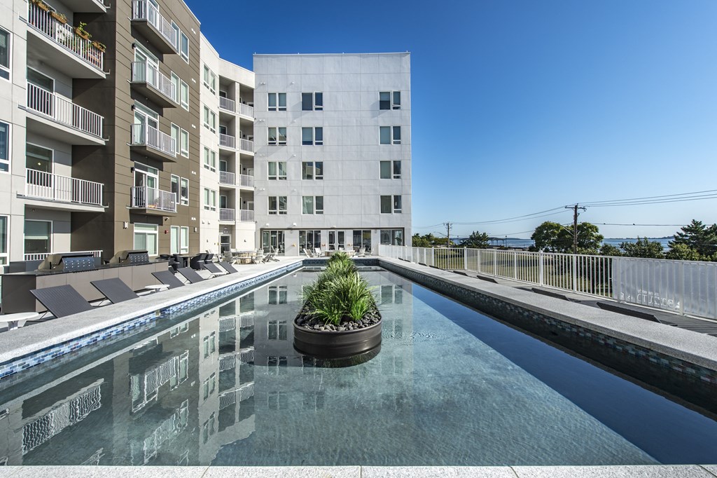 a water feature with an apartment building in the background