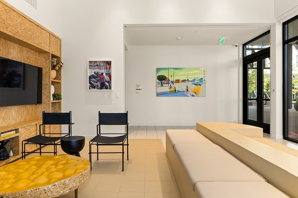 A living room with a yellow table and two chairs.