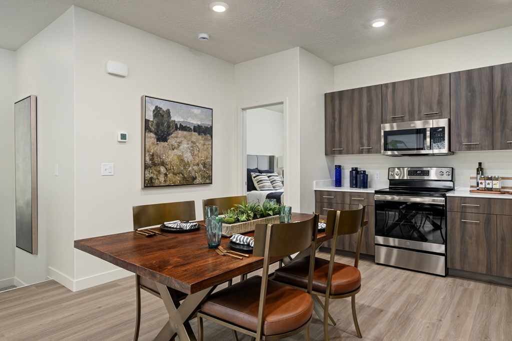 A modern kitchen with a wooden dining table and chairs.