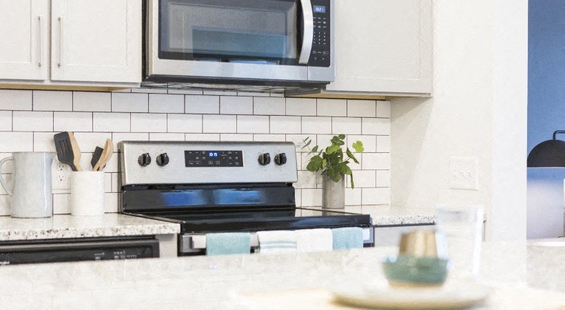 a white kitchen with a stove and a microwave