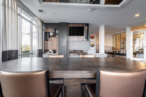 A modern dining room with a long table and chairs.