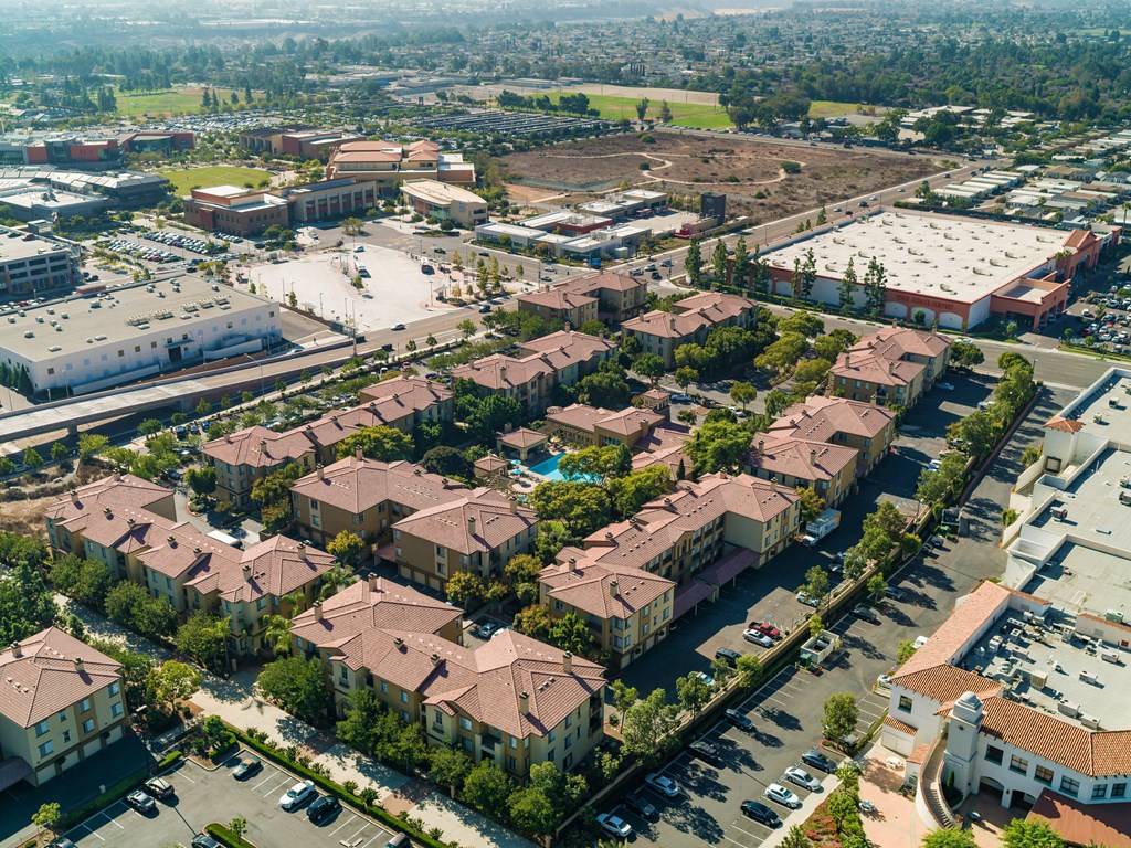 A bird's eye view of a residential area with houses and a parking lot.