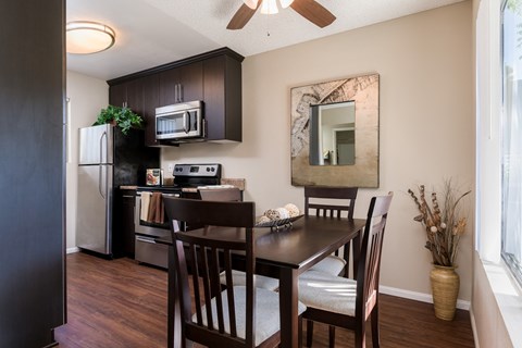 A kitchen with a table and chairs.