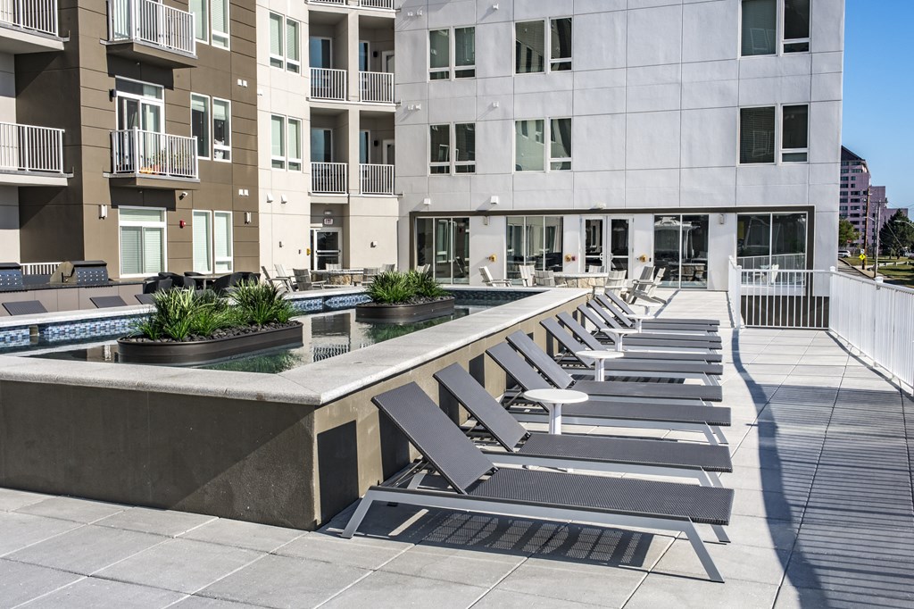 a water feature with lounge chairs in front of a building