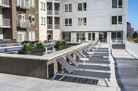 a water feature with lounge chairs in front of a building