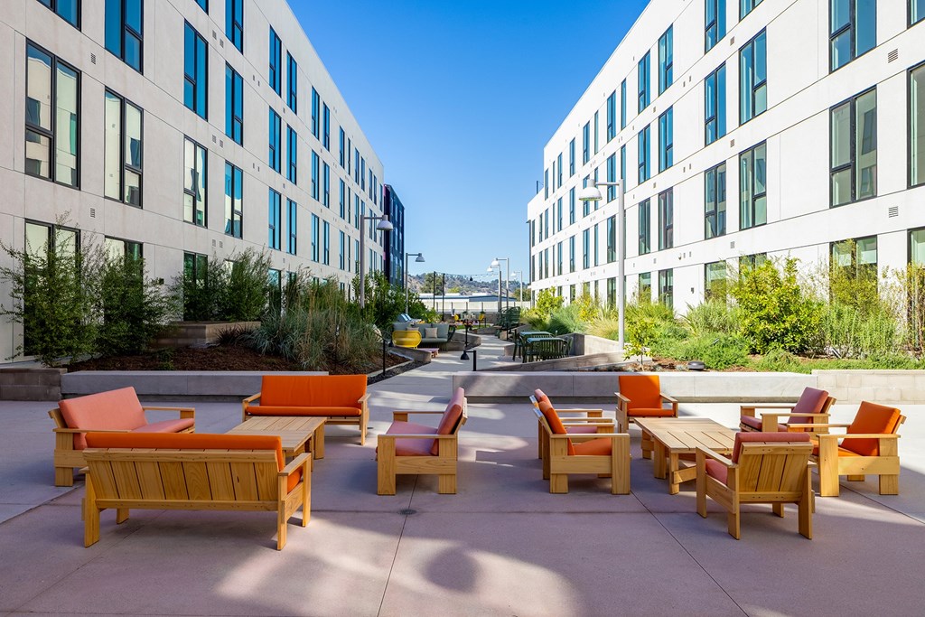 A sunny day at a modern outdoor seating area with wooden furniture.