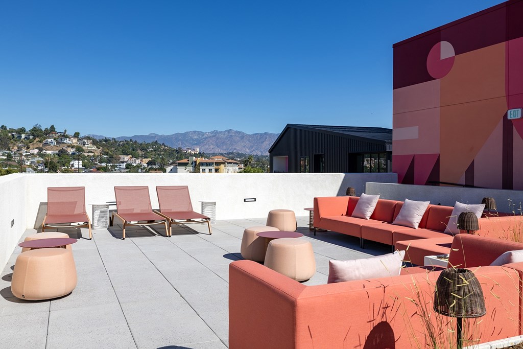 A patio with red chairs and tables.