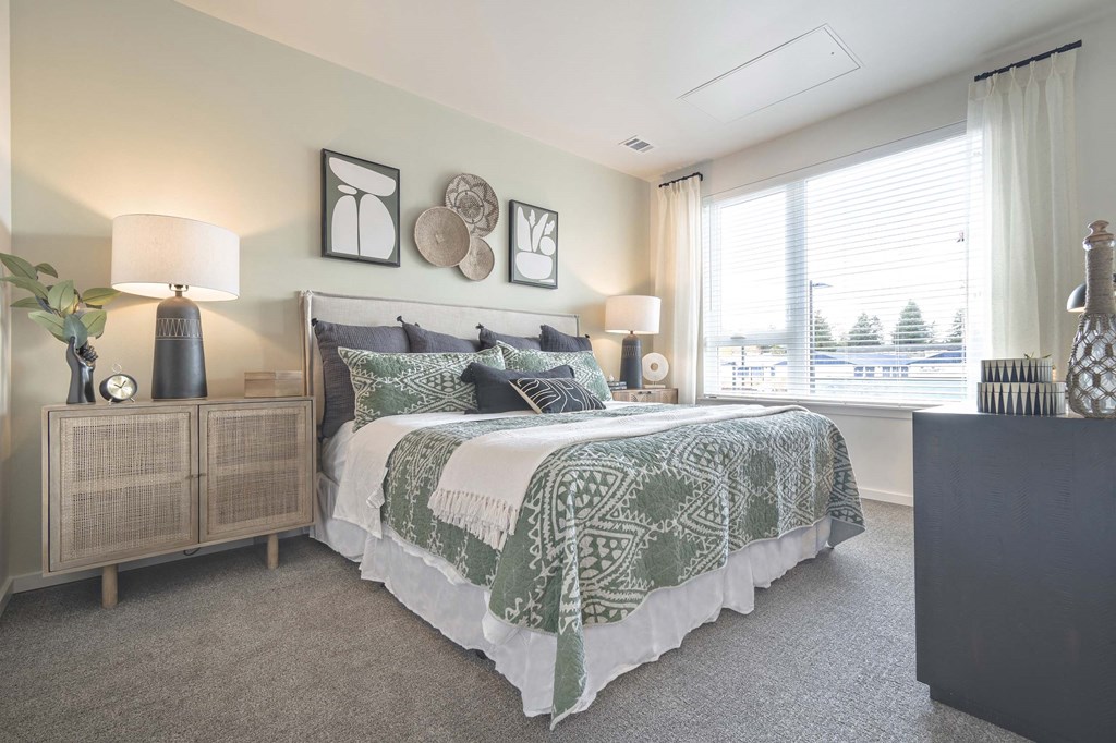 a bedroom with a bed and a large window