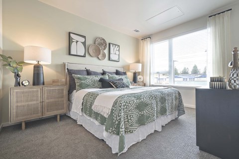 a bedroom with a bed and a large window
