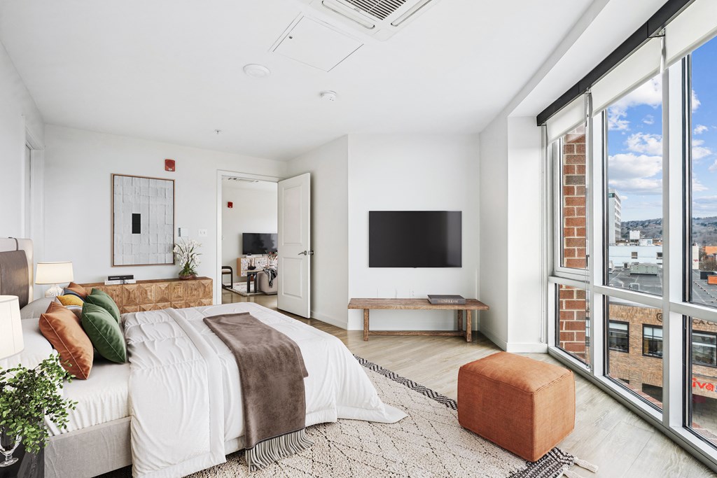 a bedroom with a bed and a large window