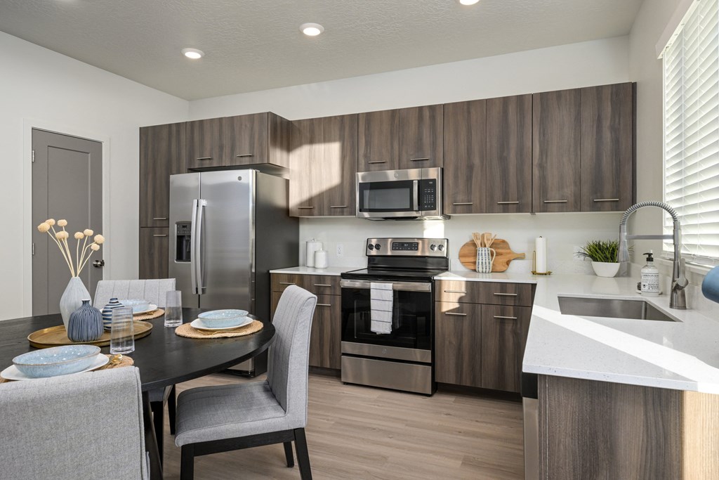 A modern kitchen with a dining table set for two.